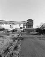 Carreau de Soumont : bâtiment dit de criblage et convoyeur à minerai, vue prise de l'ouest.- Photographie ancienne, 1981.