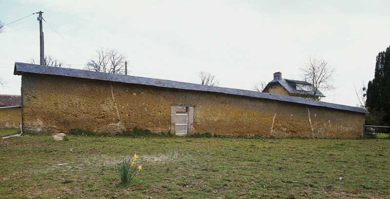 Feugères. Manoir, actuellement ferme. Mur en bauge du potager.