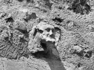Tour dite "Tour du chartrier". Détail d'une sculpture en remploi représentant un visage humain.