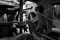 Atelier de fabrication. Vue intérieure. Mécanisme d'entraînement des meules du moulin, support des courroies.