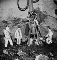 Intérieur d'une galerie : machine d'extraction avec ouvriers.- Photographie ancienne, s.d. (Archives privées Société des Mines de Soumont).