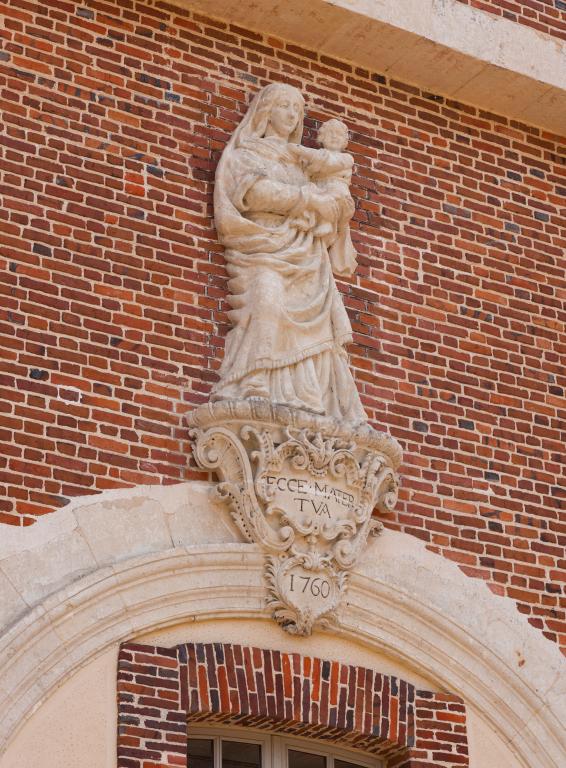 Détail de la façade nord de la porterie : haut-relief de la Vierge à l'Enfant surmontant l'ancienne porte charretière.