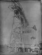 Chevalement et bâtiment d'extraction.- Photographie ancienne, contact de plaque de verre 18x24, vers 1920. (Archives privées Société des Mines de Soumont).