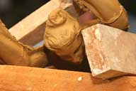 Reportage sur la fabrication d'un épi de faîtage dans l'atelier de poterie. Estampage : pièce moulée, avec et posée sur des contraintes pour garder les tensions de la pièce, détail.