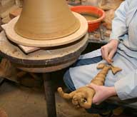 Reportage sur la fabrication d'un épi de faîtage dans l'atelier de poterie. Décoration de la base de l'épi : préparation de la pièce moulée.