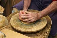 Reportage sur la fabrication d'un épi de faîtage dans l'atelier de poterie. Tournage : début du façonnage de la base de l'épi.