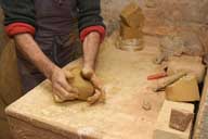 Reportage sur la fabrication d'un épi de faîtage dans l'atelier de poterie. Tournage : préparation de la matière première (malaxage).