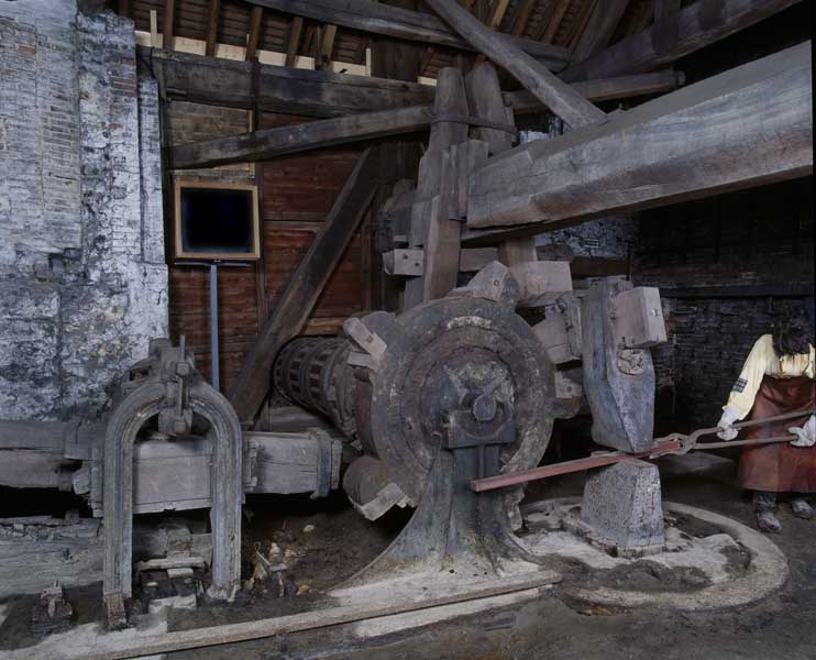 Atelier de fabrication, vue intérieure : marteau hydraulique. Détail : arbre à cames et tête du marteau.