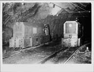 Intérieur d'une galerie : locomotives tractant les wagons.- Photographie ancienne, s.d. (Archives privées Société des Mines de Soumont).