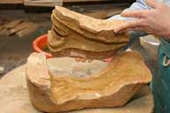 Reportage sur la fabrication d'un épi de faîtage dans l'atelier de poterie. Estampage : superposition des deux parties du moule pour sa fermeture.