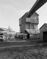 Carreau de Soumont : bâtiment dit de criblage et départ du convoyeur à minerai vers les fours à griller, vue prise du nord-ouest.- Photographie ancienne, 1981.