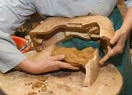 Reportage sur la fabrication d'un épi de faîtage dans l'atelier de poterie. Estampage : démoulage (5), pièce moulée retirée du moule.