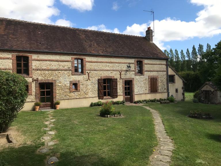 Ferme, hameau de L'Hôtel Gage : exemple de mise en oeuvre en moellons de silex avec encadrements de baies, chaînages d'angle, bandeaux, corniche et souche de cheminée en brique.