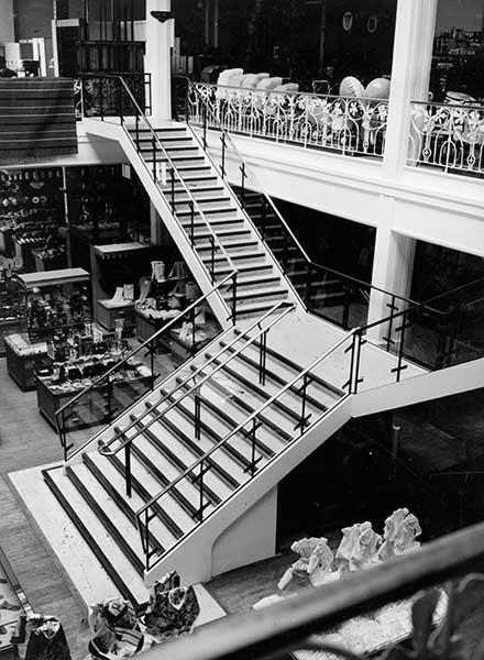 Magasin Ratti, escalier central menant au premier étage.- Photographie ancienne, 1960. (Archives privées de la famille Ratti, Cherbourg-Octeville).