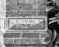 Mur de clôture du logement (2). Détail : nom de l'entrepreneur (F. Huvé, à Lisieux).