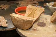 Reportage sur la fabrication d'un épi de faîtage dans l'atelier de poterie. Estampage : détail de la partie avant remplie.