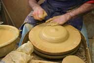Reportage sur la fabrication d'un épi de faîtage dans l'atelier de poterie. Tournage : façonnage de la base de l'épi.