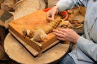 Reportage sur la fabrication d'un épi de faîtage dans l'atelier de poterie. Estampage : finition sur pièce moulée, reprise de la queue.