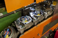 Détail de la chaîne de convoyage de la machine à agrafer avec boîtes de camembert de marque Lanquetot.