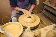 Reportage sur la fabrication d'un épi de faîtage dans l'atelier de poterie. Tournage : façonnage de la partie haute de la base de l'épi.