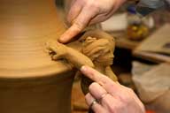 Reportage sur la fabrication d'un épi de faîtage dans l'atelier de poterie. Décoration de la base de l'épi : soudure de la pièce et de la pièce moulée, estompage des marques, partie supérieure.