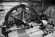 Atelier de fabrication. Vue intérieure. Mécanisme d'entraînement des meules du moulin, rouet de fosse.