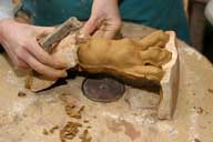 Reportage sur la fabrication d'un épi de faîtage dans l'atelier de poterie. Estampage : démoulage (6), partie inférieure du moule retirée.