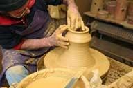Reportage sur la fabrication d'un épi de faîtage dans l'atelier de poterie. Tournage : façonnage de la partie haute de la base de l'épi.