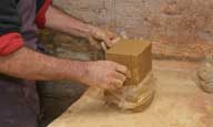 Reportage sur la fabrication d'un épi de faîtage dans l'atelier de poterie. Tournage : matière première.