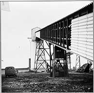 Puits central de May-sur-Orne. Bâtiments des bandes transporteuses de minerai, vue latérale.- Photographie ancienne, 1962.